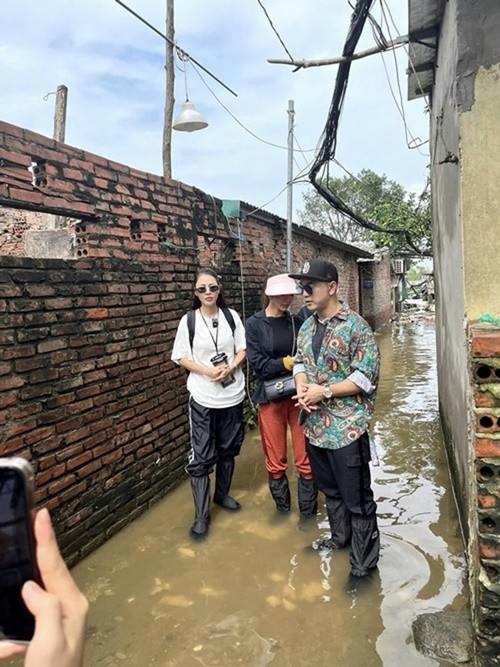  Ưng Hoàng Phúc cùng Kim Cương, Quế Vân đi trao quà cho bà con ở Phúc Tân (Hoàn Kiếm, Hà Nội). Nhiều người tranh cãi việc bộ ba ngồi thuyền hỗ trợ dù mức nước mới chỉ đến đầu gối, lựa chọn góc quay. Ảnh: FB Quế Vân.