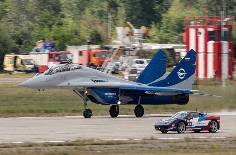 Trong ảnh là một chiếc tiêm kích MiG-29 đang thực hiện màn đua tốc độ với mẫu xe Ferrari 458 Italy, trong khuôn khổ các hoạt động trình diễn ngoài trời trong triễn lãm Oboronexpo-2014.