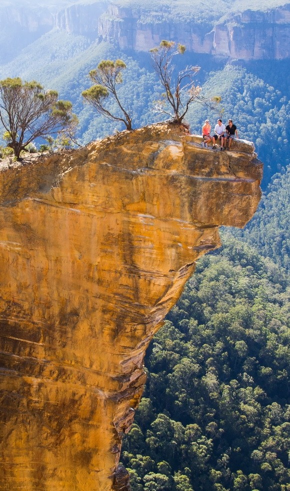  1. Hanging Rock, Australia  Hanging Rock nằm ở thị trấn Blackheart (cách Sydney khoảng gần 100 km về phía Tây). Mỏm đá này nằm cách mặt đất khoảng 100m và chìa hẳn ra ngoài khoảng không rộng lớn. Du khách phải thật gan dạ để có thể trèo qua một đoạn đường nhỏ, hẹp và ngồi trên mỏm đá chỉ rộng gần 50cm. Phần thưởng cho sự gan dạ của du khách đó là có cơ hội được chiêm ngưỡng bức tranh thiên nhiên tuyệt đẹp của thung lũng Grose và dãy núi Blue ở phía dưới.