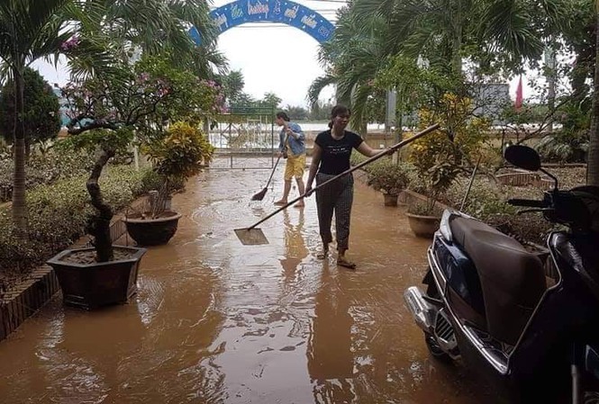 Người dân ở (phường 3, TP Đông Hà, tỉnh Quảng Trị) cho hay mọi người đã tranh thủ đẩy bùn ra ngoài cùng lúc nước rút, nhưng không thể nào đẩy hết. Trên tường và các vật dụng bùn vẫn còn bám dày, khoảnh sân trước nhà anh bùn non cao ngập mắt cá chân. (Ảnh: Tiền Phong).