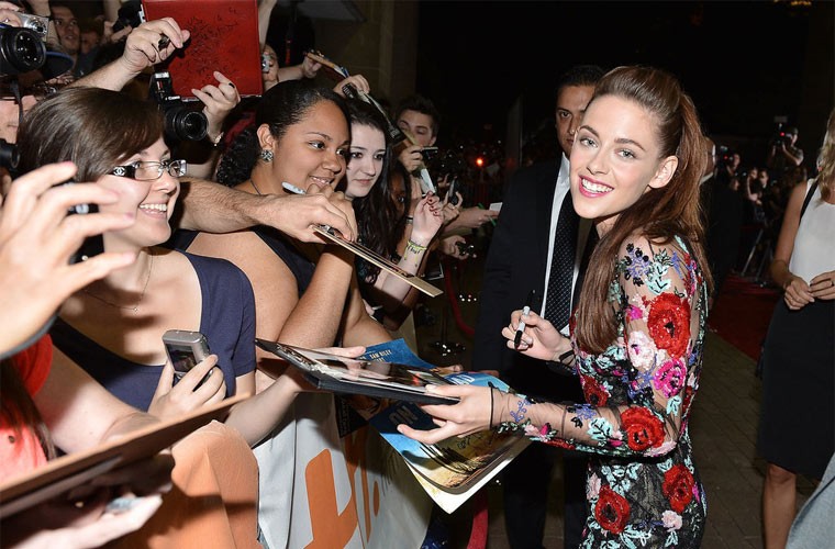 Kristen Stewart tươi cười ký tặng fan trong một sự kiện.