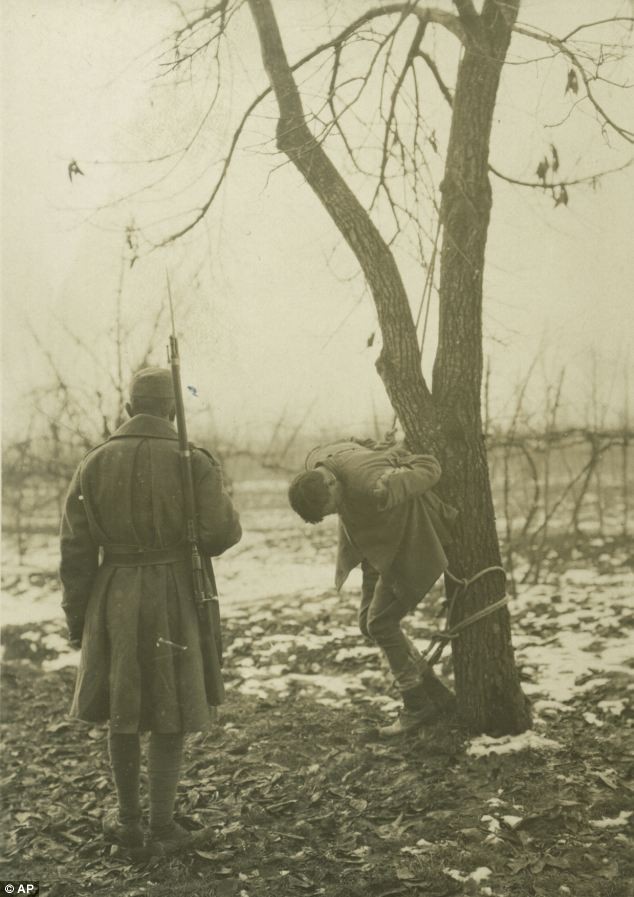 Một binh sĩ Italy đứng trước một tù nhân chờ bị hành hình tại chiến trường Italy năm 1917.