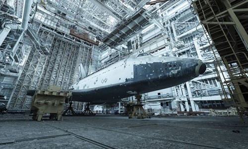 Nhiếp ảnh gia người Pháp David de Rueda ghé thăm một hangar (nhà chứa tàu bay) tại Baikonur Cosmodrome, Kazakhstan. Ông đã đến đây 3 lần trong thời gian từ năm 2015 - 2017. Tại đây, Rueda đã chụp ảnh những  tàu con thoi một thời của Liên Xô. Chúng bị phủ bụi dày trong gần 30 năm qua. Trong ảnh là tàu con thoi Buran một thời của Liên Xô.