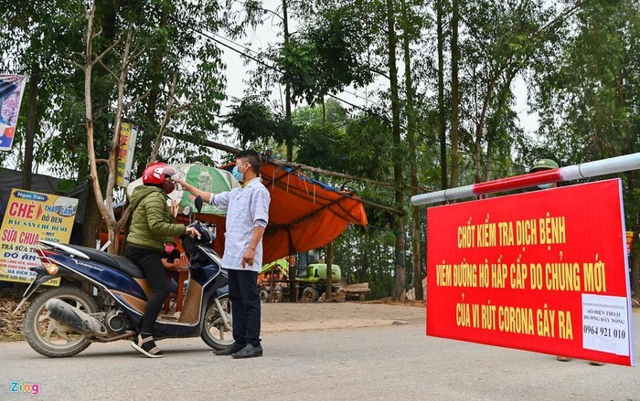 Con đường dẫn vào xã Sơn Lôi, huyện Bình Xuyên, tỉnh Vĩnh Phúc những ngày này luôn có lực lượng an ninh chốt chặn 24/24h làm công tác  đo thân nhiệt người ra vào, hướng dẫn người dân đeo khẩu trang đúng cách.