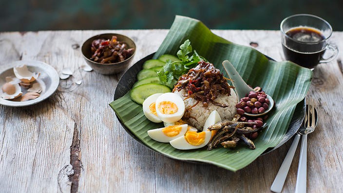 Nasi Lemak: Đây là bữa ăn sáng yêu thích nhất của người Malaysia, thường được gói trong lá chuối. Bên trong là cơm trắng được nấu cùng với sữa hoặc kem dừa nên có mùi rất thơm, ăn kèm với cá cơm chiên, sambal (bột tôm cay), trứng chiên hoặc luộc, đôi khi có thêm chút đậu phộng.