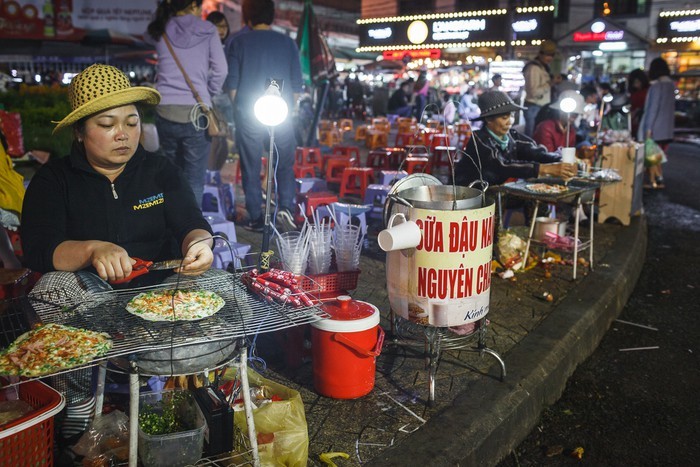 Bánh tráng nướng được coi là  món ăn vặt số 1 tại chợ đêm Đà Lạt. Những chiếc bánh vừa ra lò nóng hổi chắc chắn sẽ làm ấm bụng du khách trong tiết trời se lạnh tại Đà Lạt. Ảnh: Zing.