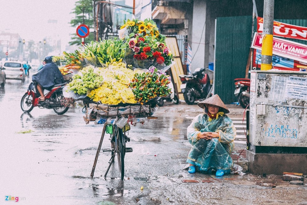 Ba ngày nay, không khí lạnh tăng cường khiến Bắc Bộ mưa rét, tuy nhiên nhiều người vẫn ra đường mưu sinh khi nhiệt độ giảm còn 15 độ C. Một người bán hoa dầm mình giữa mưa chờ người mua.