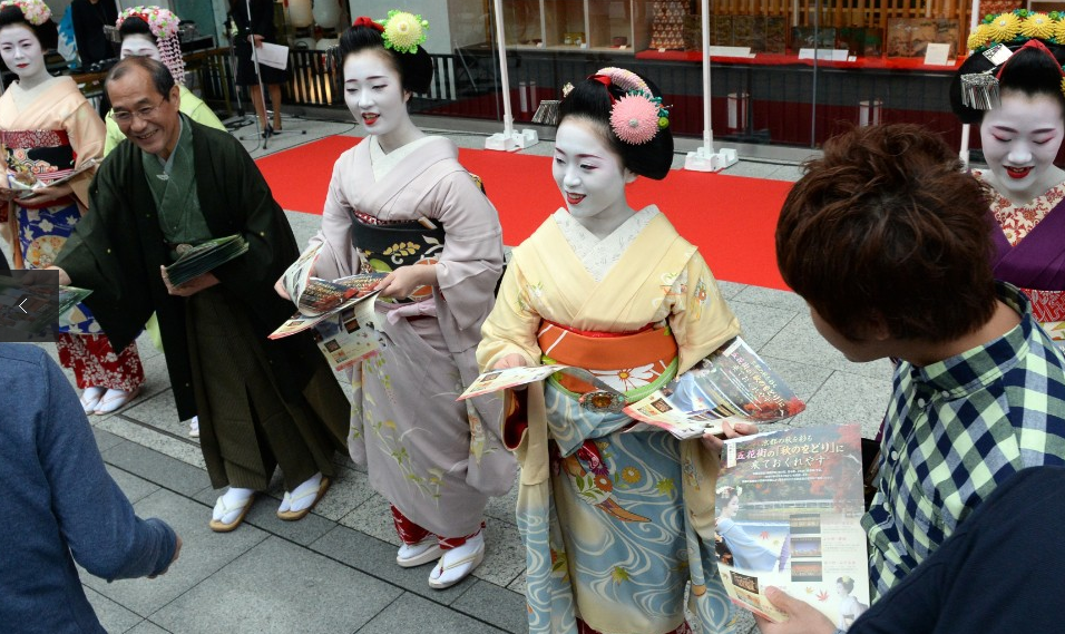 Một nhóm kỹ nữ Nhật geisha đã có màn tiếp thị đặc biệt ở thành phố Tokyo, Nhật Bản khi cùng nhau xếp hàng phát tờ rơi cho một chiến dịch mang tên “We are alive and well, Kyoto" (Chúng tôi vẫn tồn tại và phục vụ tốt, Kyoto).