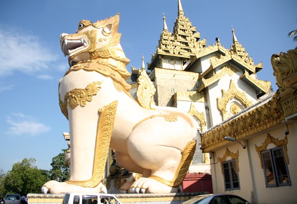 Chùa lại nằm trên đồi Singuttara, từ đây có thể quan sát được cả cố đô Yangon (Myanmar). Từ chân đồi có 4 lối leo lên chùa. Mỗi lối lên có một cặp sư tử thần canh gác. Lối phía đông và phía nam có rất nhiều cửa hàng bán dụng cụ thờ Phật và dụng cụ tu hành. Ảnh: Cặp sư tử thần canh gác trước các lối dẫn vào.