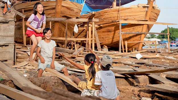 Những đứa trẻ ở thôn Cổ Lũy, xã Nghĩa Phú, huyện Tư Nghĩa (Quảng Ngãi) chơi trò bập bênh bằng những tấm ván đóng tàu đánh cá - Ảnh: Tiến Thành