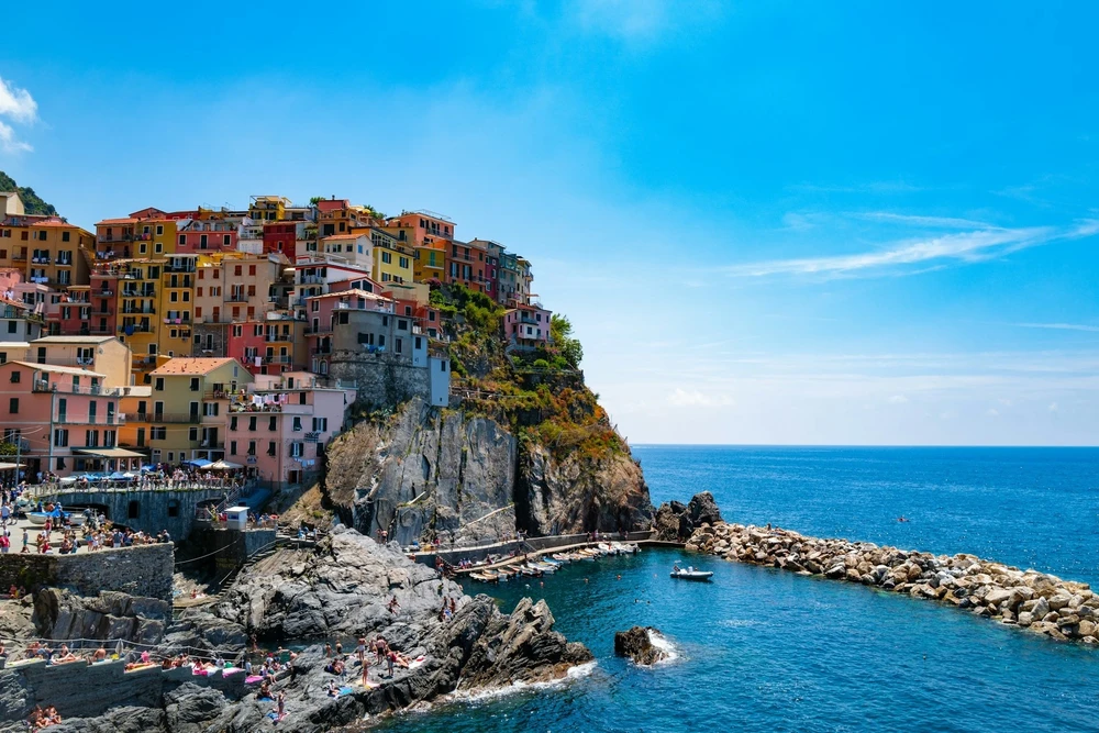 Manarola, thị trấn nhỏ thứ 2 trong 5 thị trấn đẹp như tranh vẽ ở Cinque Terre (Italy), chật cứng du khách. "Nhanh lên, Manarola cần nhiều khách du lịch hơn nữa!", nữ quản lý người Italy nói bằng tiếng Anh khi nhìn thấy đám đông chen chúc trên tàu và giữa sân ga. Không để ý đến sự mỉa mai của cô, du khách di chuyển nhanh về phía trước và tản ra ngoài bến du thuyền nhỏ để chụp một bức ảnh hoàn hảo trên bờ biển Riviera để đăng lên mạng xã hội Instagram, theo The Guardian. Ảnh: Vincenzo Landino/Unsplash.