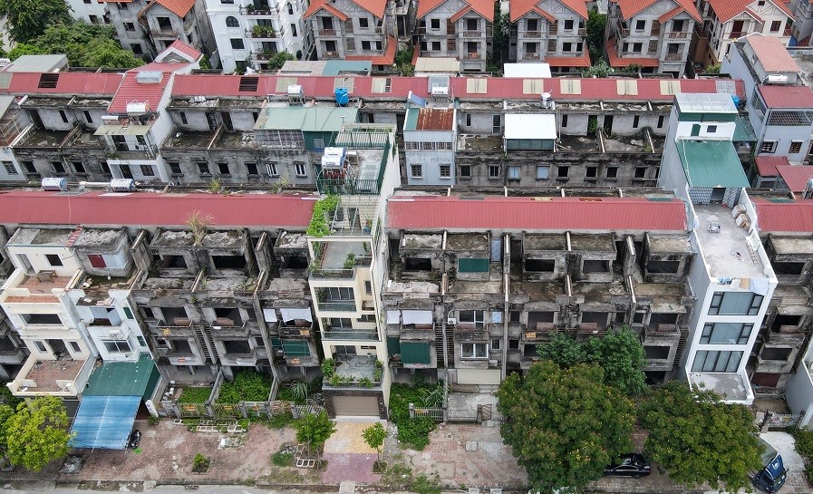 Tại khu đô thị Vân Canh (Hoài Đức, Hà Nội), hàng loạt dãy nhà liền kề xây thô bị bỏ hoang lâu năm, rêu mốc đen. Ảnh: Dân trí