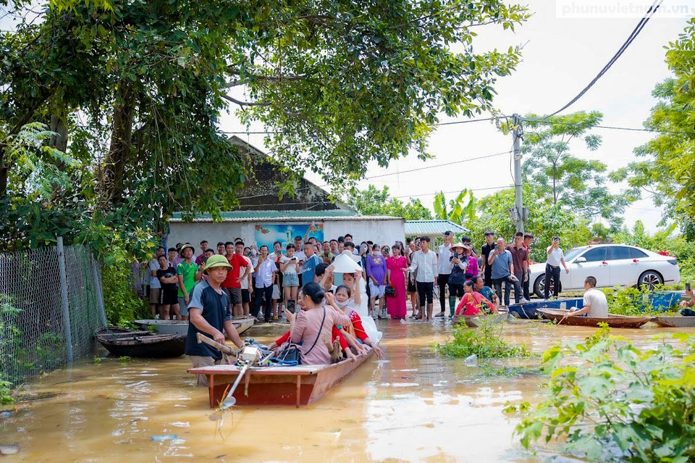 Trên MXH những đám cưới đón dâu bằng thuyền phao tự chế không hiếm nhưng mỗi lần xuất hiện nó lại khiến nhiều người chú ý. Mới đây nhất, đám cưới của cặp đôi gen Z là Nguyễn Thị Huyền và Nguyễn Văn Luyện tại huyện Chương Mỹ - Hà Nội nơi đang bị ngập lụt nghiêm trọng là một điểm hình. Ảnh: Phụ nữ Việt Nam