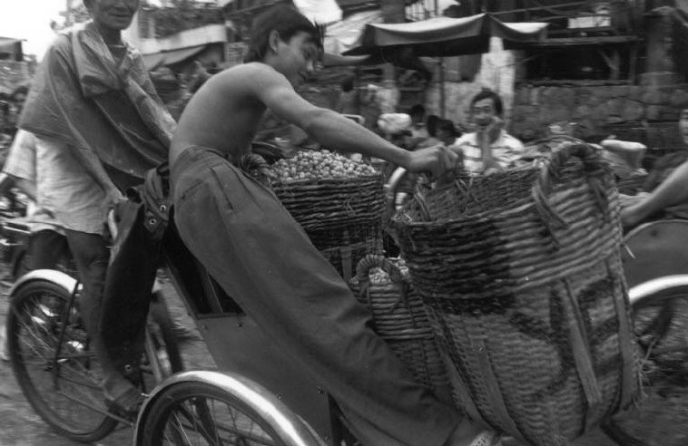 Cậu bé giữ các giỏ hàng trên một chiếc xích lô,  Sài Gòn năm 1993. Ảnh: Ferdinando Scianna/ Magnumphotos.com.