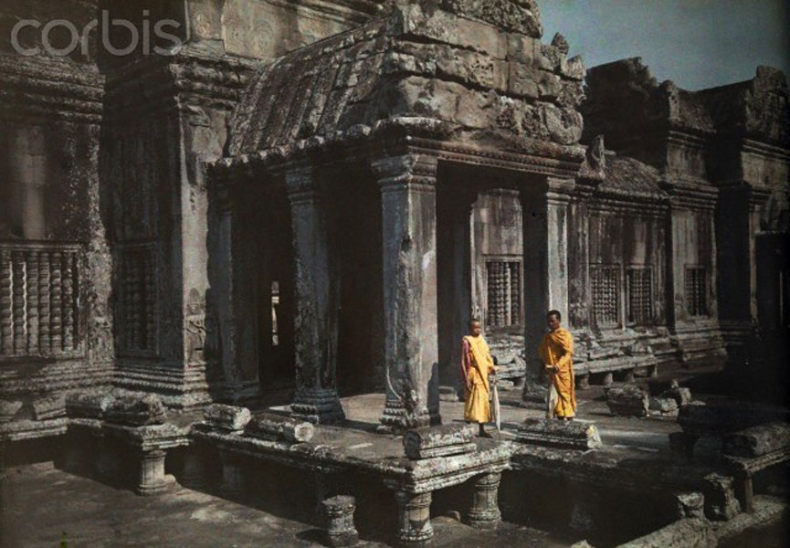 Hai nhà tu hành trẻ người Khmer đứng trước một cánh cổng ở phế tích Angkor Wat,  Campuchia năm 1930. Ảnh: National Geographic.