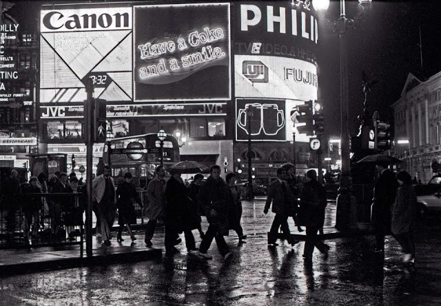 Khánh bộ hành đi lại nhộn dịp bên các biển hiệu quảng cáo rực rỡ ở giao lộ Piccadilly Circus, một hình ảnh quen thuộc của  London xưa do nhiếp ảnh gia Chris Hogg thực hiện. Ảnh: Vintag.