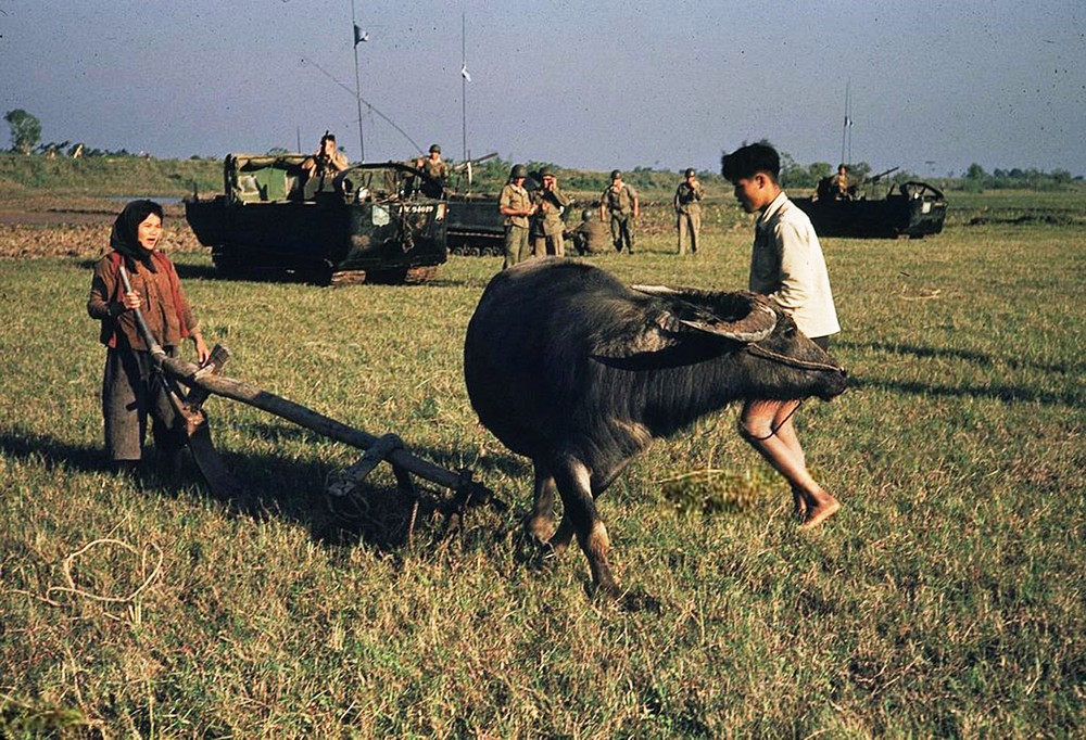  Lính Pháp xem hai nông dân Việt cày ruộng ở Phủ Lý, tỉnh Hà Nam, Việt Nam năm 1954. Ảnh tư liệu.