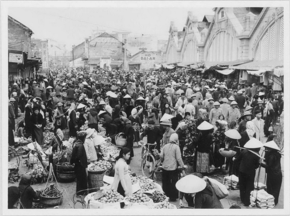 Cảnh họp chợ phía trước chợ Đồng Xuân, Hà Nội dịp  Tết Nguyên đán Ất Mùi, 1955. Ảnh: Viện Viễn Đông Bác Cổ (EFEO).