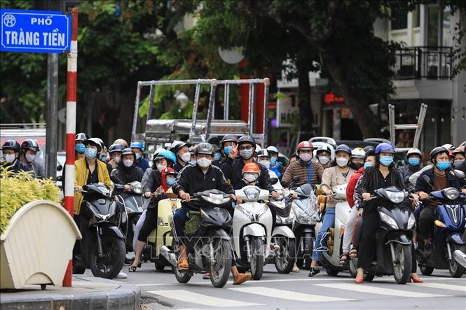 Theo ghi nhận của phóng viên những người tham gia giao thông dừng đèn đỏ đều tuân thủ đeo khẩu trang  phòng chống dịch vừa là bảo vệ sức khỏe tránh ô nhiễm cho bản thân. Ảnh: Thành Đạt/TTXVN