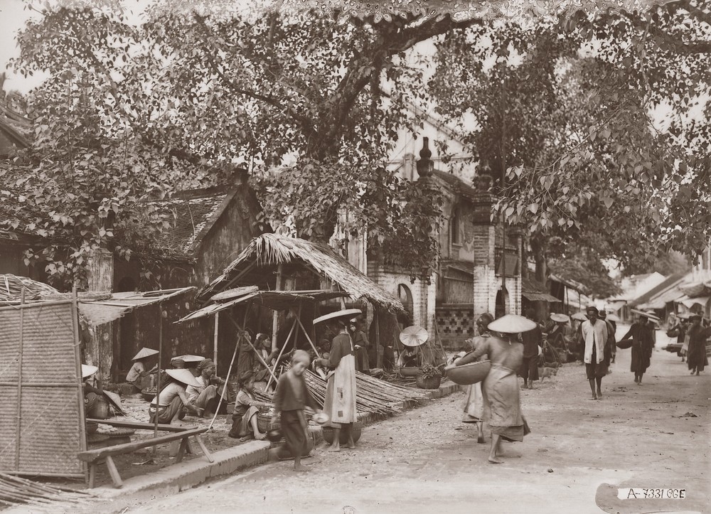 Một góc chợ Bưởi thập niên 1920, vị trí đầu đường Thụy Khuê hiện tại. Cảnh cổng tam quan bên đường là của đỉnh An Thái (nay ở số 595 Thụy Khuê). Đây là khu chợ của Kẻ Bưởi, nơi có ba làng chuyên nghề làm giấy nên người Pháp thường gọi là làng Giấy (Village du Papier).