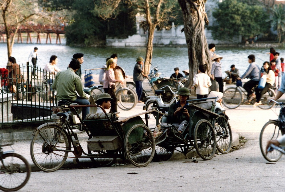 Khu vực đài phun nước Long Vân bên bờ  hồ Hoàn Kiếm, phía xa là cầu Thê Húc và đền Ngọc Sơn, Hà Nội năm 1990. Ảnh: Diligam_te Flickr.