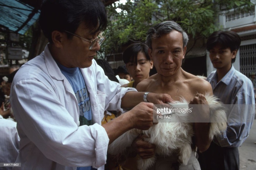 Bác sĩ thú y tiêm phòng dại cho chó ở TP HCM,  Việt Nam năm 1994. Ảnh: Eric Raz/Gamma-Rapho via Getty Images.