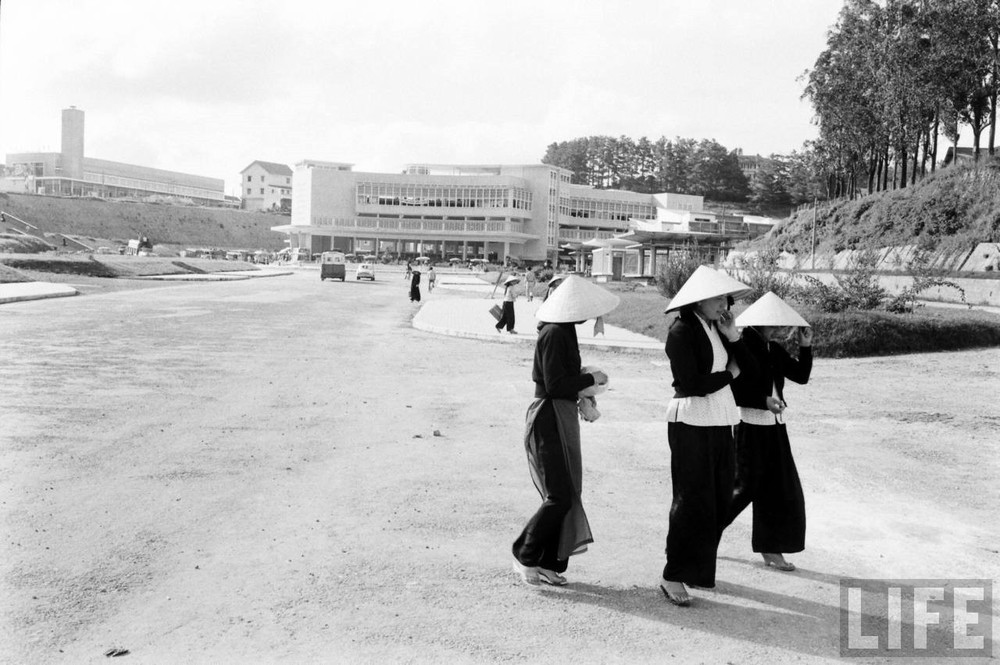 Những người phụ nữ đi ngang qua khu vực phía trước  chợ Đà Lạt mới, Đà Lạt năm 1961. Góc trái phía trên bức ảnh là hội trường Hòa Bình, chính là chợ Đà Lạt cũ, nay là Rạp 3 Tháng 4. Ảnh: John Dominis / Life.