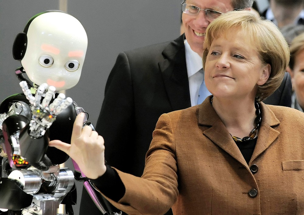  Thủ tướng Đức Merkel làm cử chỉ với một chú robot ở cạnh Thống đốc bang Hạ Saxony Christian Wulff trong phiên khai mạc hội chợ công nghiệp Hanover ngày 10/4/2010.