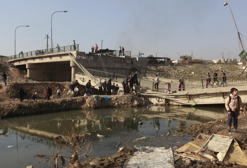 Những người dân Iraq vô tội trên đường trốn chạy phiến quân IS đang vượt qua sông ở khu dân cư Al-Muthanna,  chiến trường Mosul. Ảnh Reuters