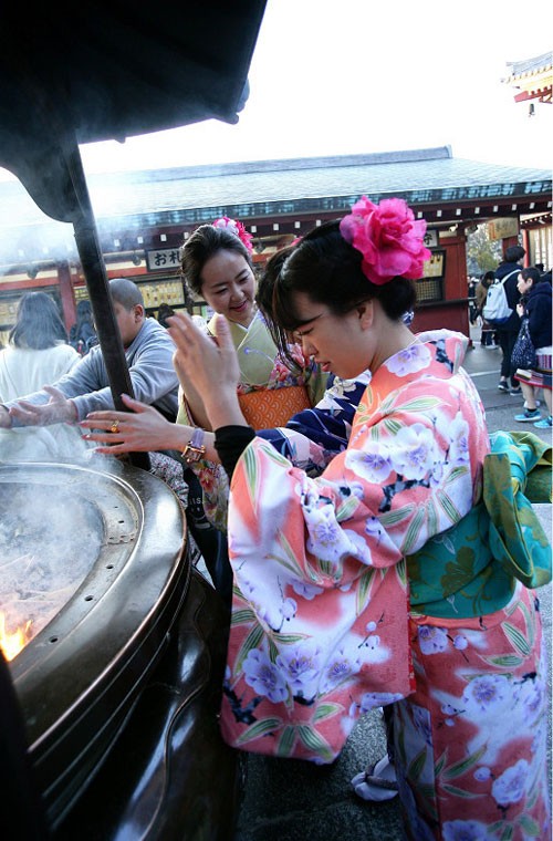 Các thiếu nữ Nhật Bản mặc kimono thành tâm cầu khấn khi tới  đền Sensoji. Đây là hình ảnh mà các du khách Trung Quốc ghi lại được tại một trong những ngôi đền linh thiêng và cổ nhất ở Tokyo trong những ngày đầu xuân năm mới. Ảnh Sina