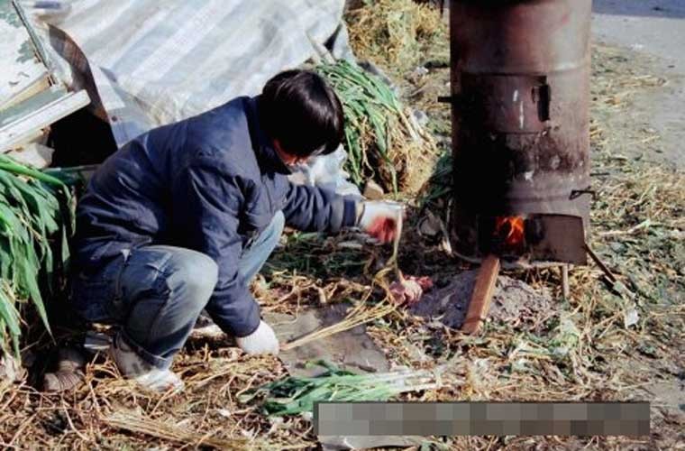 Người đàn ông ở  thủ đô Seoul, Hàn Quốc đang trông lửa một bếp nướng năm 1985. Ảnh Sina