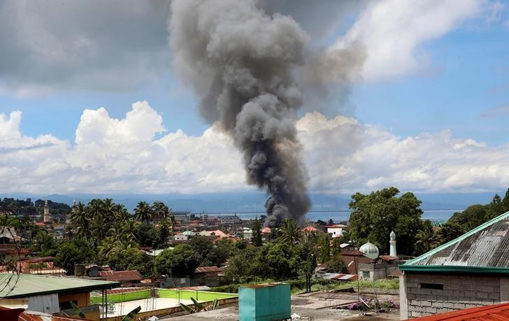 Hãng thông tấn Reuters ngày 27/5 đưa tin, lần đầu tiên các trực thăng Philippines nã tên lửa dẫn đường vào loạt vị trí của nhóm  phiến quân ở nam Philippines nhằm chấm dứt sự chiếm đóng và giành lại quyền kiểm soát thành phố Marawi trên đảo Mindanao. Trong ảnh chụp ngày 27/5, khói bốc lên từ những ngôi nhà đang cháy ở Marawi trong cuộc giao tranh giữa lính chính phủ Philippines và nhóm Maute.