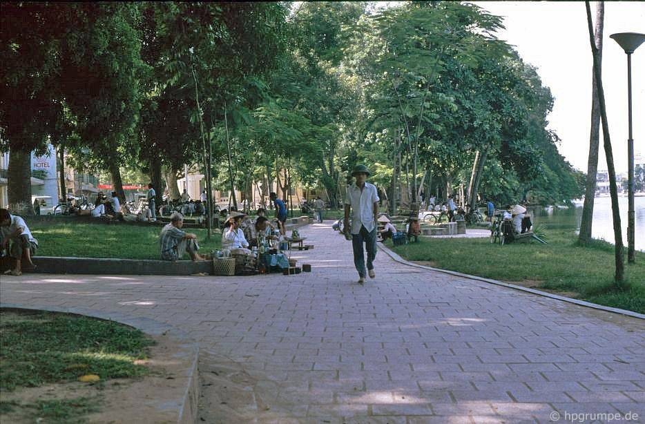 Trên vỉa hè bờ hồ Hoàn Kiếm, góc Lê Thái Tổ - Hàng Trống, Hà Nội năm 1991. Các lối đi ở vỉa hè bờ hồ thời điểm này được lát gạch hình vuông. Ảnh: Hans-Peter Grumpe / Hpgrumpe.de.