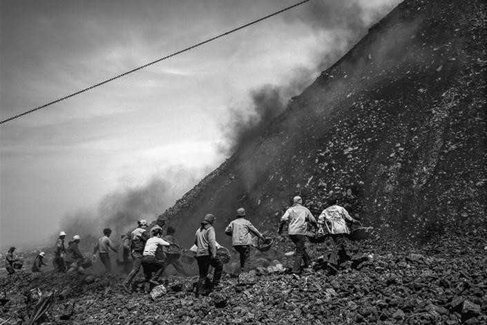 Không đợi đống đất lắng xuống, những người thu gom chạy về phía ngọn đồi, bỏ qua những rủi ro từ những mảnh vỡ rơi xuống ở thành phố Bình Đỉnh Sơn, tỉnh Hà Nam,  Trung Quốc, tháng 2/2017. Đây là một trong những bức ảnh ghi lại cuộc sống xung quanh khu vực khai thác và những ngọn đồi phế thải giữa năm 1998-2009, theo CaixingGlobal.