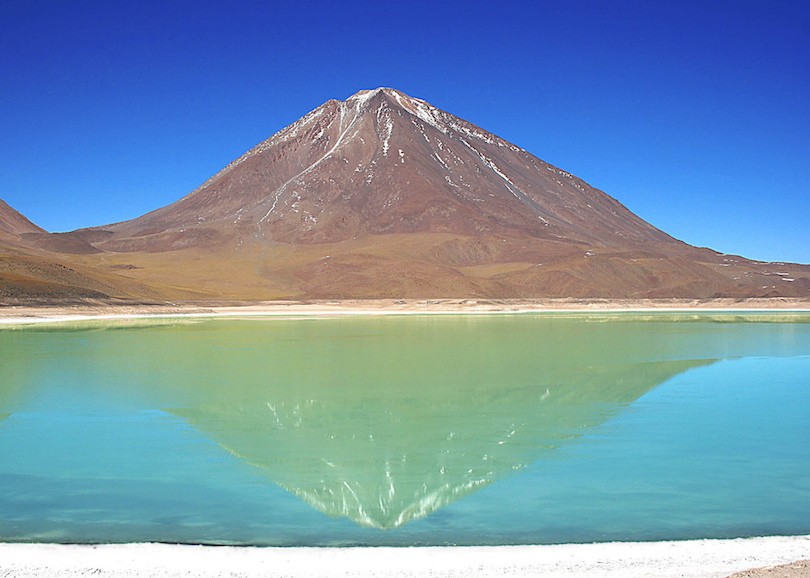 10. Laguna Verde Laguna Verde, một  hồ nước mặn, nằm ở phía tây nam của đồng bằng cao của Bolivia. Đối với những người nói tiếng Tây Ban Nha, sẽ không có gì ngạc nhiên trước vẻ đẹp của hồ nước với tên gọi Laguna Verde (Đầm xanh) này. Hồ có một màu xanh tuyệt vời. Nằm dưới chân núi lửa Licancabur, màu xanh lá cây tươi đẹp của nước hồ cộng hưởng với màu vàng đồng của ngọn núi tạo thành một khung cảnh nên thơ.