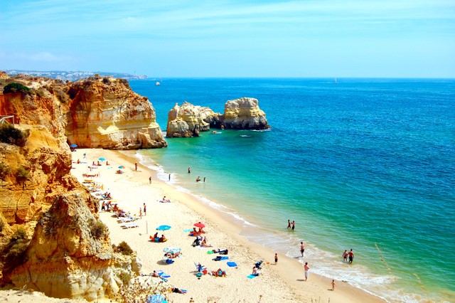 Bãi biển ở Algarve,  Bồ Đào Nha, có ánh nắng ấm áp cùng những bãi biển trong xanh, nơi du khách có thể thưởng thức hải sản tươi ngon cùng nhiều môn thể thao hấp dẫn như nhảy dù đôi, chơi với cá heo, lặn biển, lướt sóng. ảnh: holidayrentals