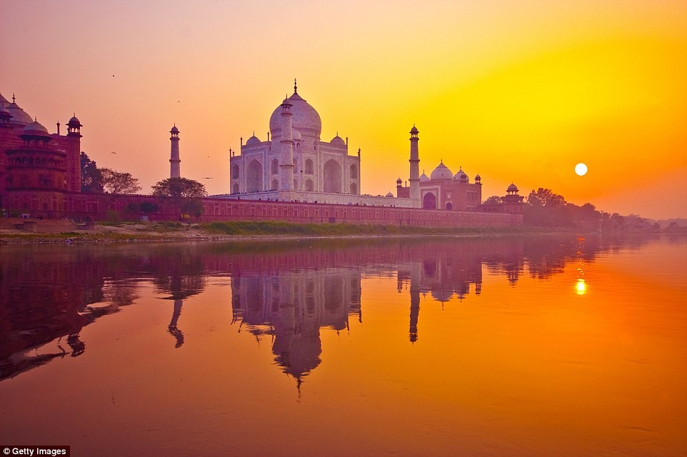  Cảnh hoàng hôn đẹp mê hồn ở lăng Taj Mahal của Ấn Độ. Ánh nắng mặt trời cuối ngày phản chiếu xuống mặt nước hồ thành một màu da cam kỳ lạ.