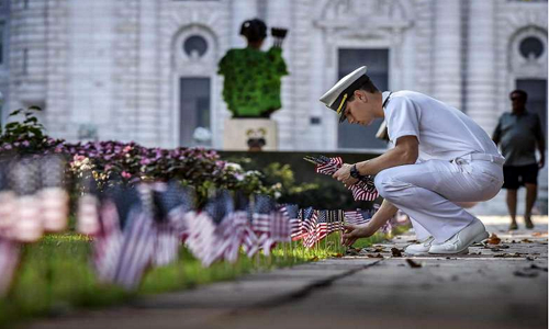 Một người lính đặt cờ tưởng niệm ở Học viện Hải quân Mỹ ở Annapolis, Maryland. Ảnh: Washington Post.