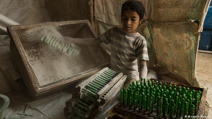 Vì gia đình quá nghèo, nhiều em nhỏ ở Bangladesh đã phải làm việc trong các nhà máy để kiếm tiền. Những đứa trẻ thường phải làm công việc nguy hiểm với mức lương bèo bọt. Ảnh: Một  lao động trẻ em Bangladesh chỉ khoảng 10 tuổi làm việc trong nhà máy ở Kamrangi Char, ngoại ô thủ đô Dhaka. Ảnh: DW.