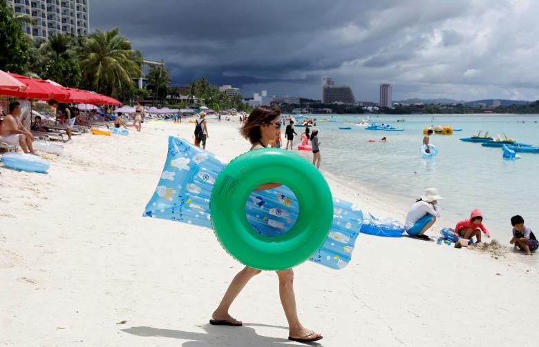 Hãng tin Reuters đăng tải loạt ảnh phần nào cho thấy  cuộc sống trên đảo Guam vẫn diễn ra bình thường trong bối cảnh Bình Nhưỡng “dọa” tấn công đảo này sau tuyên bố của Tổng thống Mỹ Donald Trump về việc đáp trả Bình Nhưỡng bằng "lửa và sự cuồng nộ". Ảnh: Các du khách trên bãi biển Tumon ở đảo Guam ngày 10/8. Ảnh: Reuters.