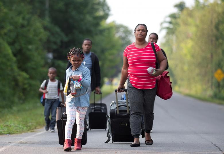 Một gia đình tị nạn Haiti trên đường  vượt biên từ Mỹ sang Canada. Theo Reuters, hàng trăm người Haiti đã vượt biên vào Quebec để xin tị nạn trong những tuần gần đây khiến tỉnh này phải huy động thêm nhân viên dịch vụ biên giới từ các tỉnh khác đến hỗ trợ.