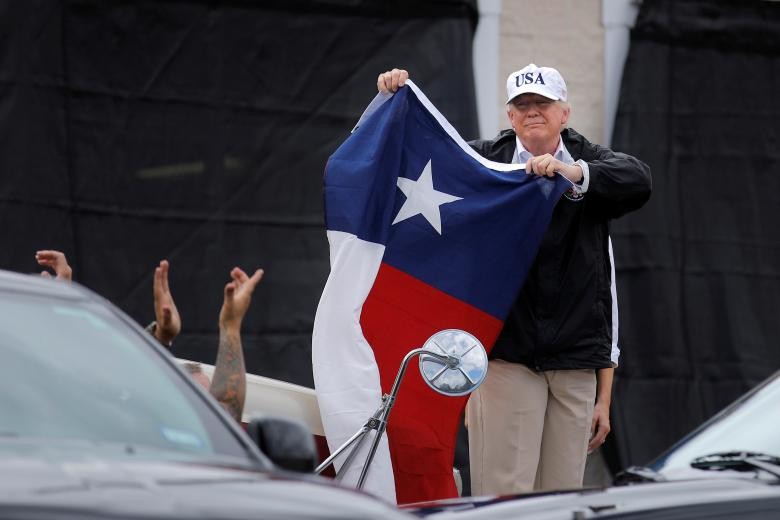 Tổng thống Mỹ Donald Trump và Đệ nhất phu nhân Melania đã tới thăm bang Texas, nơi chịu ảnh hưởng nặng nề do  siêu bão Harvey. Ảnh: Tổng thống Trump cầm lá cờ bang Texas tại thành phố Corpus Christi. (Nguồn: Reuters)