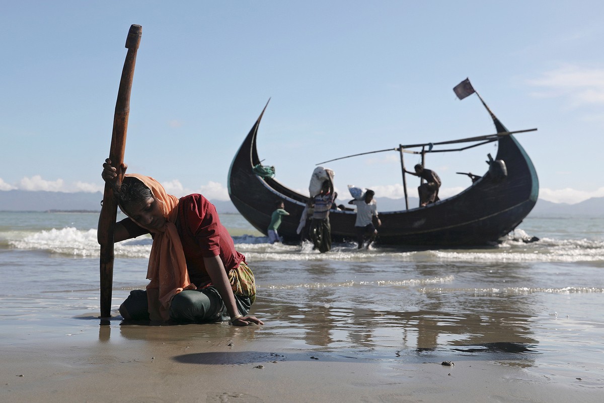 Kể từ ngày 25/8, gần 600 nghìn  người tị nạn Rohingya đã vượt biên từ bang Rakhine (Myanmar) vào Bangladesh. Ảnh: Một người phụ nữ kiệt sức sau khi đến bờ biển Shah Porir Dwip ở Teknaf, gần Cox’s Bazar (Bangladesh) từ Myanmar ngày 1/10/2017. Ảnh: The Atlantic.