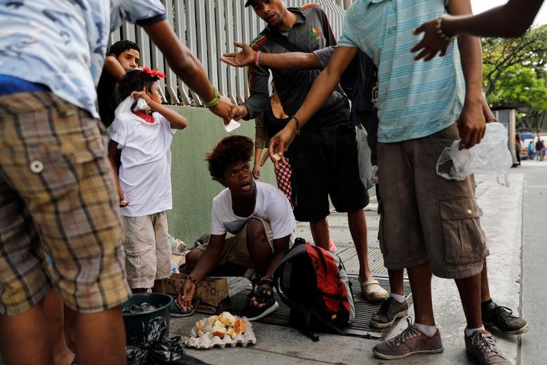 Theo hãng thông tấn Reuters, nhiều người dân nghèo ở thủ đô Caracas,  Venezuela, đã phải tìm đồ ăn trong bãi rác do giá cả thực phẩm đắt đỏ trong khi nước này vẫn chìm trong khủng hoảng. Ảnh: Một số thiếu niên ăn chiếc bánh mà họ tìm thấy trong một túi rác ở thủ đô Caracas ngày 27/2. (Nguồn ảnh: Reuters)