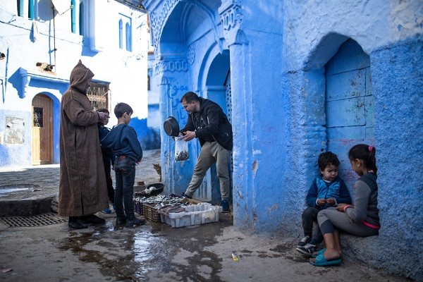 Được biết đến là "viên ngọc xanh" của Ma-rốc, thành phố Chefchaouen trước đây luôn thu hút đông đảo du khách. Tuy nhiên, do ảnh hưởng của dịch  COVID-19, thành phố này trở nên vắng vẻ lạ thường. Ảnh: Một ngư dân bán cá trên con phố nhỏ. (Nguồn ảnh: Al Jazeera)