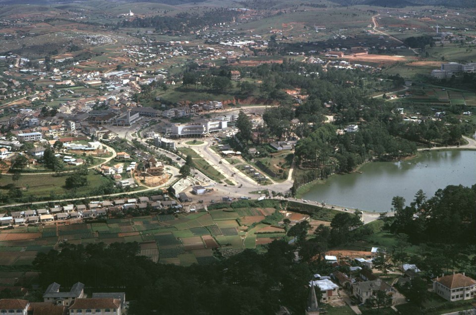 Khung cảnh trung tâm  Đà Lạt nhìn từ trên cao với một màu xanh của cây cối bao phủ gợi nhớ về một thành phố cao nguyên trong lành, yên bình, từng là nơi nghỉ dưỡng của các bậc vua chúa, quý tộc thời xưa. Bức ảnh này ghi lại quang cảnh Đà Lạt vào năm 1967 khi chưa có nhiều nhà san sát, xe cộ ít, khách du lịch thưa. Ảnh: Phillip M. Kemp.