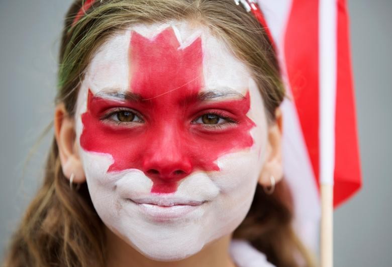 Cô gái có tên Clara Swain vẽ hình lá phong khi tham gia cuộc diễu hành kỷ niệm 150 năm  Quốc khánh Canada ở thành phố Toronto, Ontario, ngày 1/7/2017. Ảnh: Reuters.