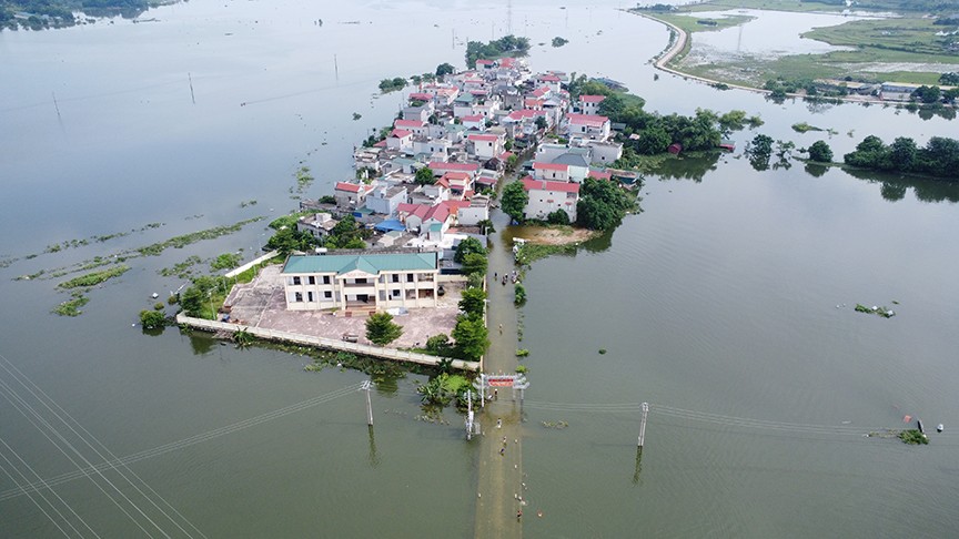 Suốt nhiều ngày qua, nước lũ các sông dâng cao,  bủa vây khiến cả xóm Bến Vôi, thôn Cấn Hạ (xã Cấn Hữu, huyện Quốc Oai, Hà Nội) chìm trong biển nước, xóm nhỏ biến thành ốc đảo. 