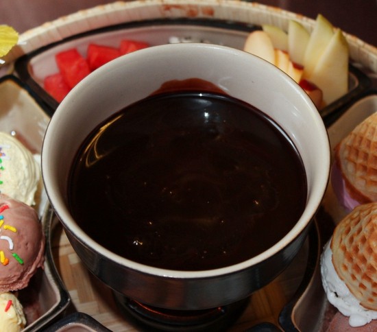 1. Lẩu chocolate. Nguyên liệu: Dâu tây, kiwi, dứa, chuối, chanh, chocolate đen, kem tươi. Cho kem tươi ra ngoài tô, để ở nhiệt độ thường. Cắt chocolate thành từng miếng nhỏ, cho vào bát đem đun cách thủy để chocolate chảy ra. Ảnh: muachung.vn.