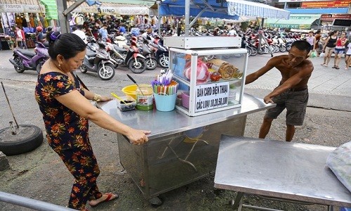 Từ khoảng 17h50 hằng ngày, nhiều tiểu thương bắt đầu dọn hàng quán ra trước cổng mặt tiền chợ Phạm Văn Hai, quận Tân Bình, TP.HCM để buôn bán, đây là khu chợ tập kết bán  hàng rong hợp pháp đầu tiên của Sài Gòn.